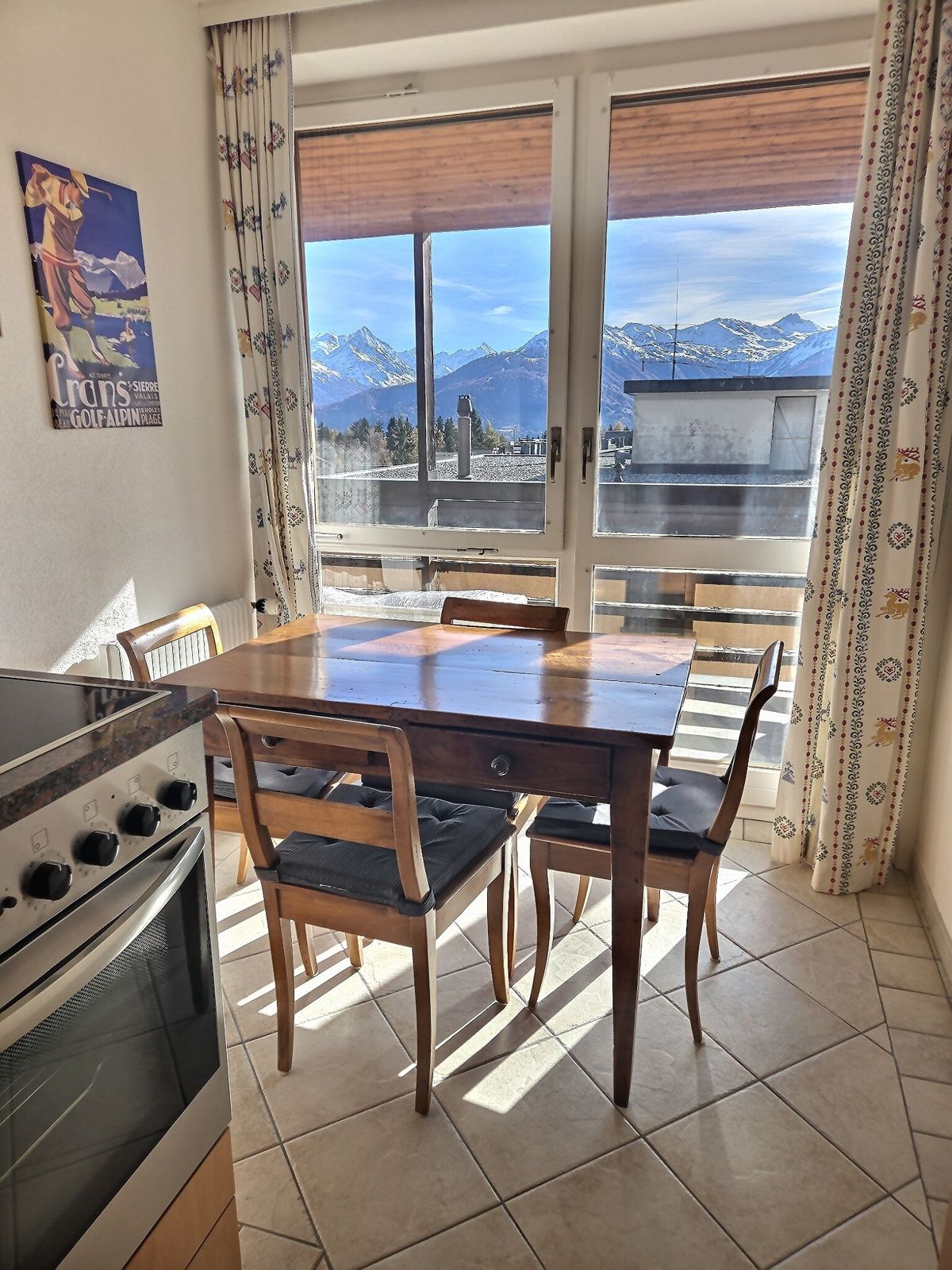 Coin repas pour 4 devant la baie avec vue sur les montagnes